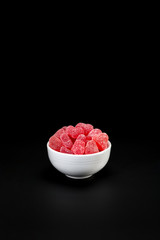 A bowl with red sugared heart candy on black
