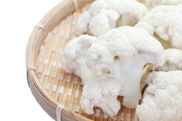 Fresh cauliflower in bamboo tray isolated on a white background