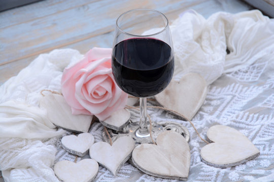 houten hart decoratie met roze roos en glas wijn