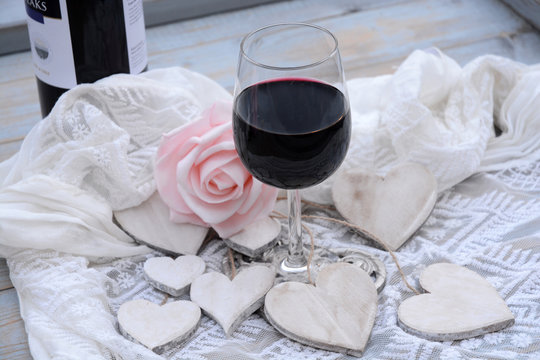houten hart decoratie met roze roos en glas wijn