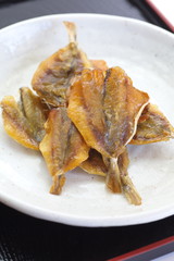 Small sweet dried fish snack on white plate
