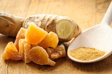 Candied fresh and ground ginger on rustic table