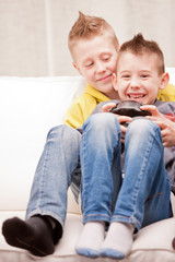 Obraz premium little brothers playing videogames together