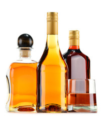 Bottles and glasses of alcoholic beverages isolated on white
