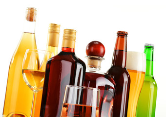 Bottles and glasses of assorted alcoholic beverages over white