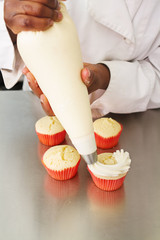 Whipped butter cream frosting applied to vanilla cupcakes