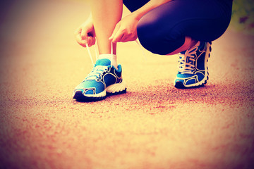  woman runmner tying shoelace outdoor