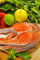 Portion of fresh salmon fillet with lemon, lime and parsley