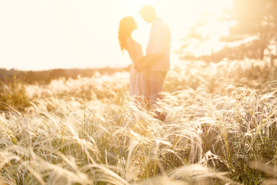 loving couple kissing at sunset, focus on foreground