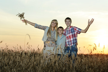Family hugs in field in sunset