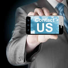 business man hand holding smartphone with the message contact us