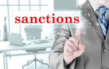 businessman pressing sanctions button on virtual screens
