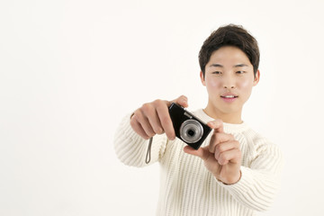 Asian young man taking photo by digital camera