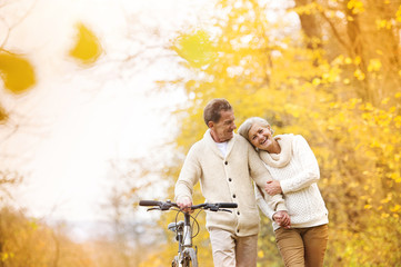 Fototapeta premium Senior couple with bicycle in autumn park