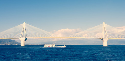 Ferry boat sailing under suspension bridge