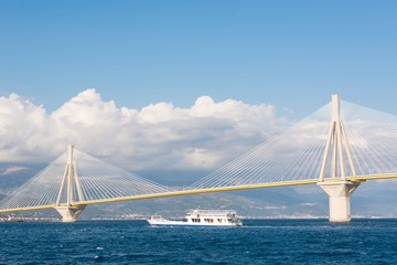 Ferry boat sailing under suspension bridge