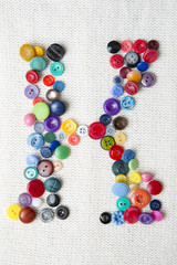Letter K of the alphabet of buttons of various shapes and colors