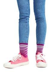 Female legs in colorful socks and sneakers isolated on white