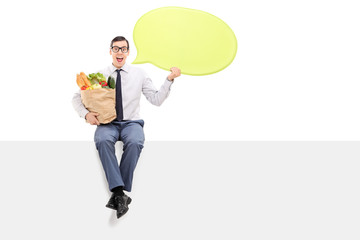 Man with groceries holding a speech bubble