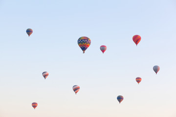 Multicolored balloons in flying in sky, sunrise time