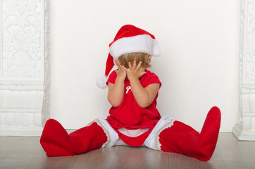 girl in costume of Santa hides his face