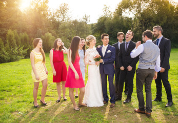 Newlyweds with guest posing in park