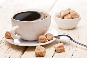 Cup of hot coffee on an old wooden table.