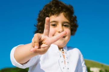 Portrait of a little cute boy raised two fingers up