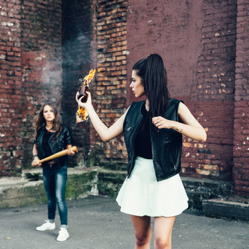 Two Bad girls with Molotov cocktail bomb in the street
