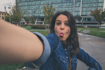 Pretty girl taking a selfie in the city streets