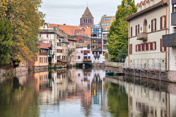 Fototapeta na wymiar Colorful houses reflecting in water of river Ill in Strasbourg