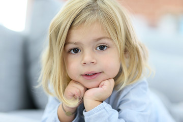 Portrait of cute little blond girl with hands on chin © goodluz