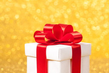 White gift box with red ribbon bow