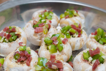 Preparing mushrooms stuffed with ham and pepper