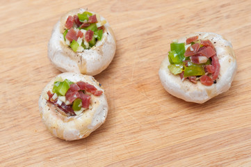 Preparing mushrooms stuffed with ham and pepper
