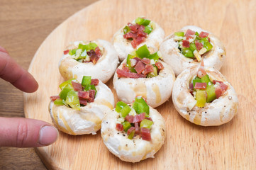 Preparing mushrooms stuffed with ham and pepper