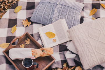 still life with tea, french loaf, knitted pillows and book 