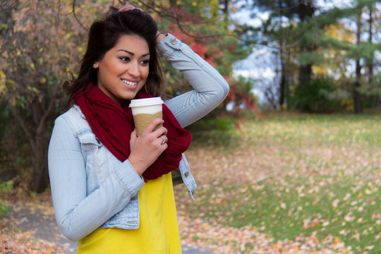 Woman drinking a beverage outside during autumn