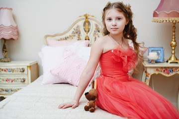 Девочка в красном платье в детской комнате