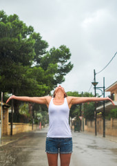 Happy blonde woman enjoying tropical rain.