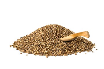 Pile of hemp seeds with a wooden spoon on white background