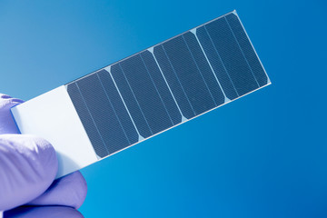 silicon crystal with photovoltaic cells in the hand of the scien
