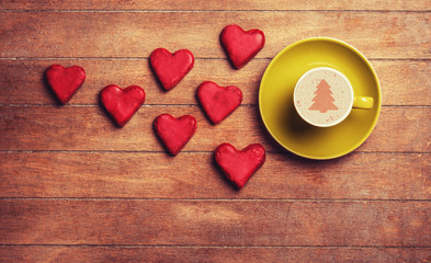 Cup of coffee and cookie on a wooden table.