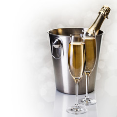 Champagne bottle in bucket with glasses of champagne