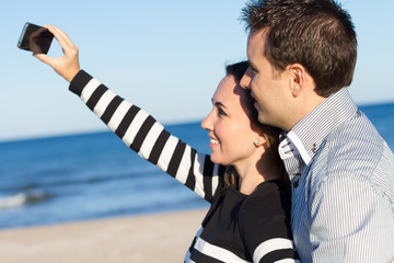 Young couple taking selfie at the beach