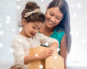 happy mother and child girl with gift box