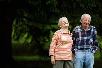 Happy senior couple looking at camera and laughing