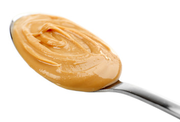 Creamy peanut butter in spoon, isolated on white