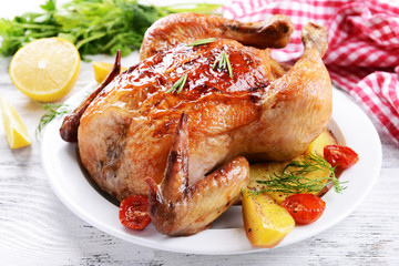 Delicious baked chicken on plate on table close-up