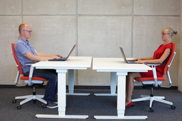 couple in correct sitting posture at workstations  in office